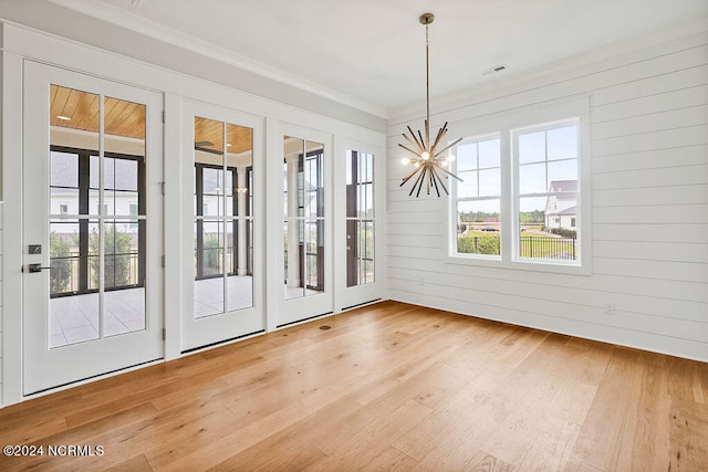 entryway featuring ornamental molding, a chandelier, and light wood-type flooring