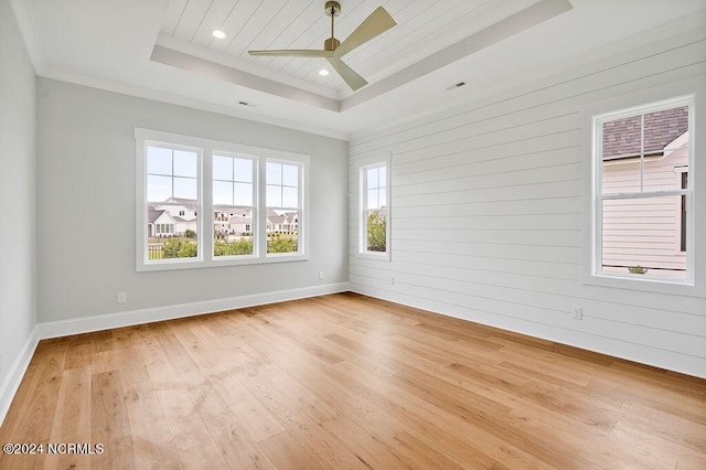 spare room featuring ceiling fan, light hardwood / wood-style floors, and a tray ceiling