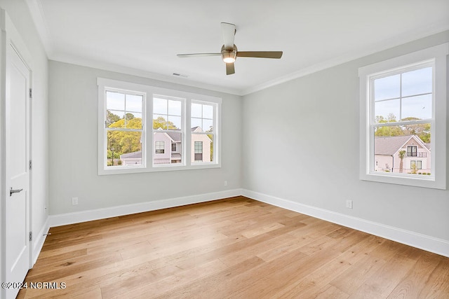 empty room with crown molding, a wealth of natural light, ceiling fan, and light wood-type flooring