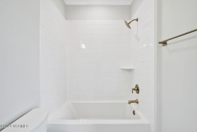 bathroom featuring tiled shower / bath combo and toilet