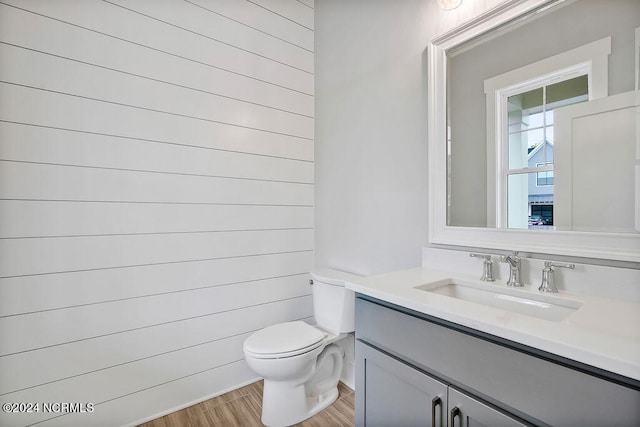 bathroom with toilet, vanity, and wood-type flooring