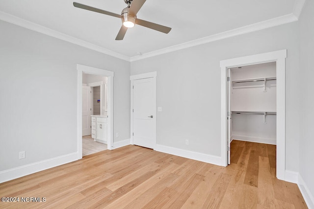 unfurnished bedroom featuring ceiling fan, crown molding, light hardwood / wood-style floors, and a closet