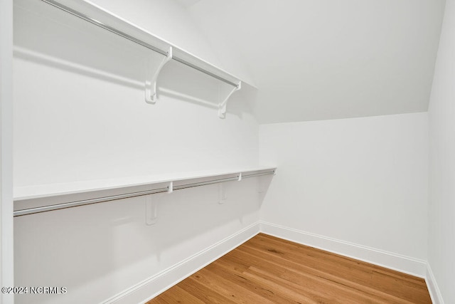 spacious closet featuring vaulted ceiling and light hardwood / wood-style flooring