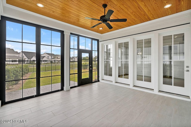 unfurnished sunroom with french doors, a healthy amount of sunlight, and ceiling fan