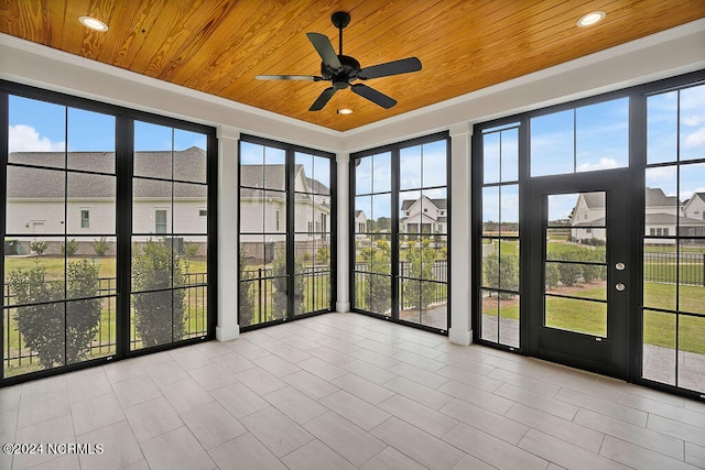 unfurnished sunroom featuring ceiling fan, plenty of natural light, and wood ceiling