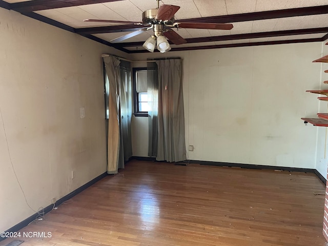 empty room featuring ceiling fan, hardwood / wood-style floors, and beam ceiling