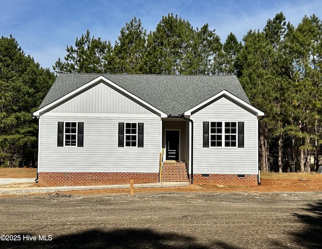 view of front facade featuring crawl space and a shingled roof