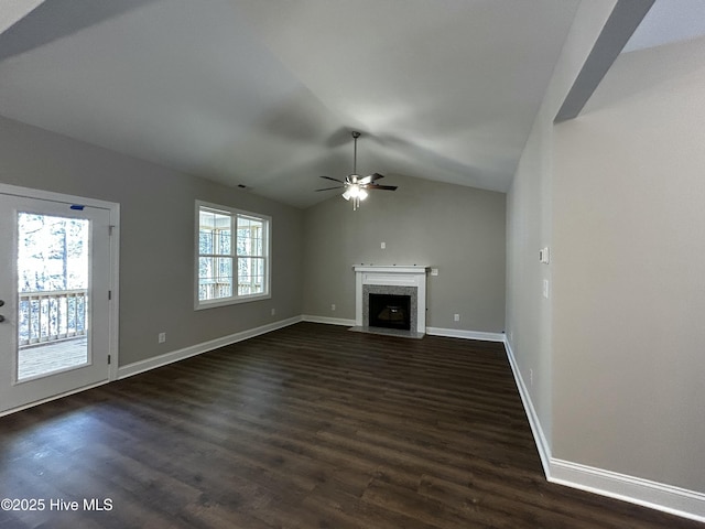 unfurnished living room with dark wood-style floors, vaulted ceiling, and a premium fireplace