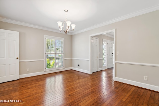 empty room featuring crown molding, dark hardwood / wood-style floors, and a chandelier