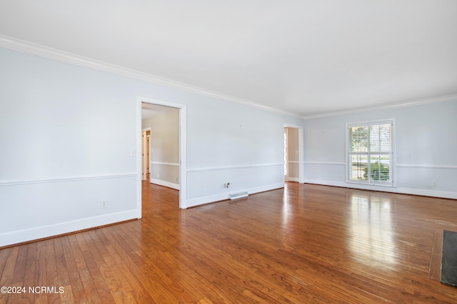 unfurnished room featuring crown molding and dark wood-type flooring