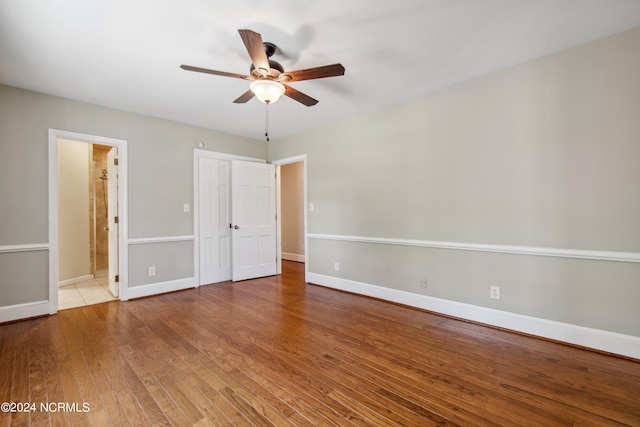 unfurnished bedroom with connected bathroom, ceiling fan, and light wood-type flooring