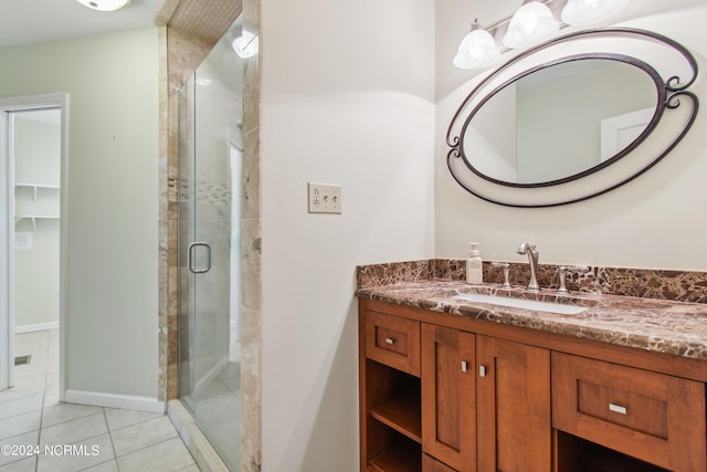 bathroom with tile floors, a shower with door, and oversized vanity