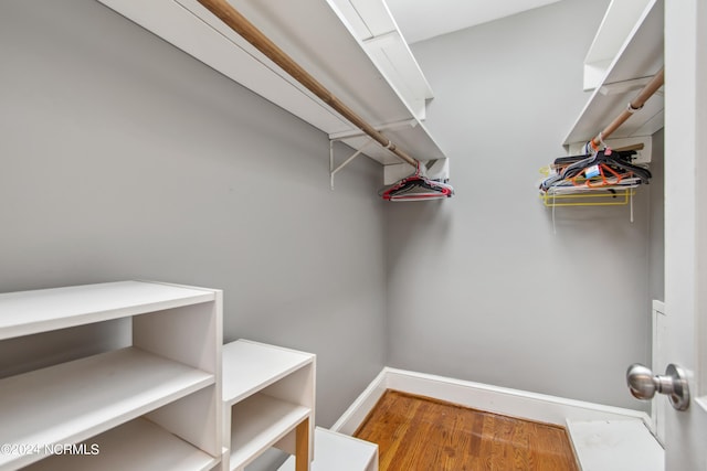 walk in closet with hardwood / wood-style floors