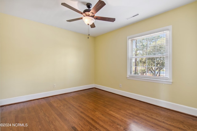 spare room with dark wood-type flooring and ceiling fan