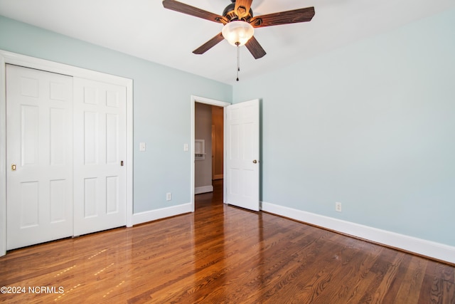 unfurnished bedroom featuring dark hardwood / wood-style flooring, ceiling fan, and a closet