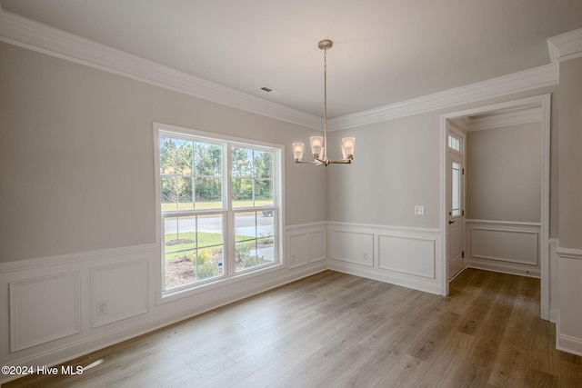 unfurnished dining area featuring a wealth of natural light, crown molding, and wood-type flooring