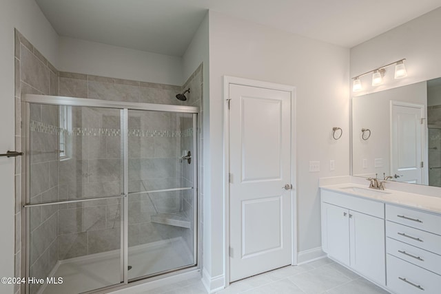 bathroom with tile patterned flooring, vanity, and walk in shower