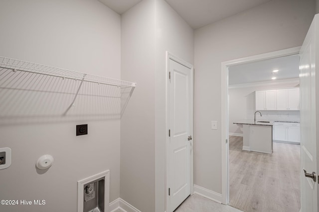 laundry area featuring hookup for an electric dryer, light hardwood / wood-style floors, and washer hookup