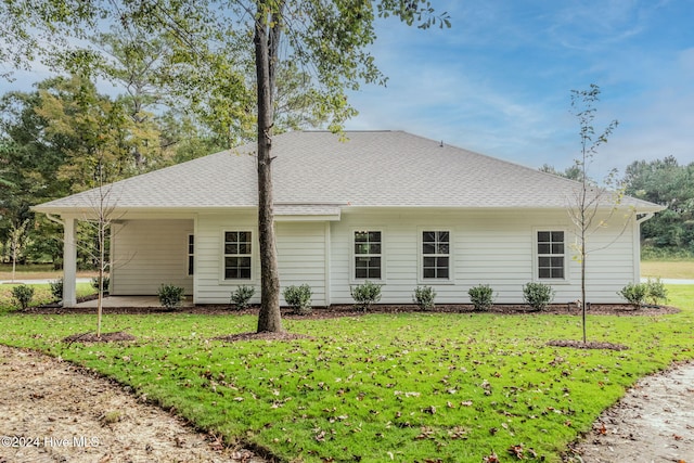 rear view of property featuring a yard