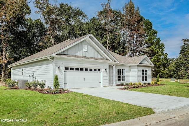 view of front of home with central air condition unit, a front lawn, and a garage