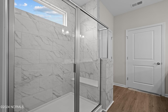 bathroom featuring hardwood / wood-style floors and a shower with shower door