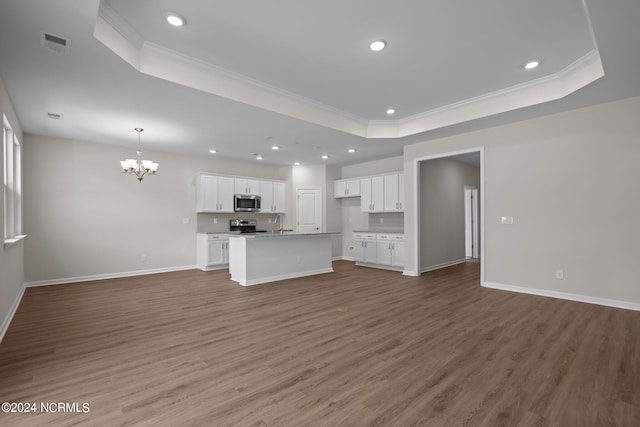 unfurnished living room featuring a notable chandelier, dark hardwood / wood-style flooring, and a tray ceiling