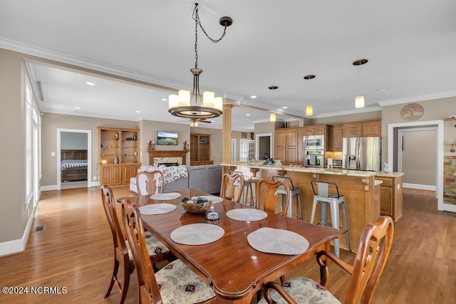 dining room featuring light hardwood / wood-style floors, crown molding, and a notable chandelier