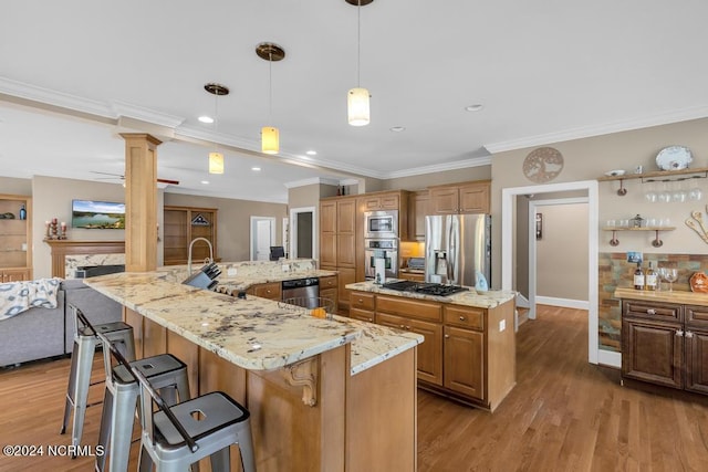 kitchen featuring a large island, stainless steel appliances, a high end fireplace, decorative light fixtures, and a breakfast bar