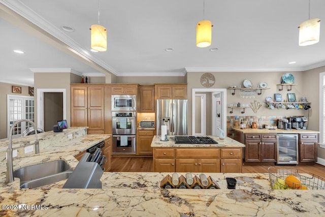 kitchen with pendant lighting, beverage cooler, stainless steel appliances, and sink