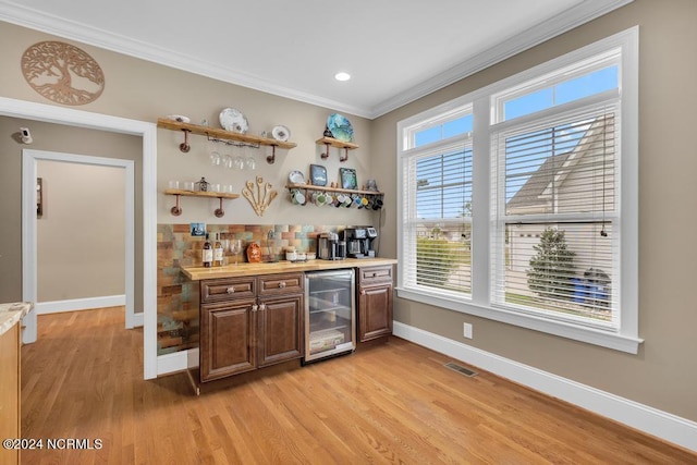 bar with wood counters, light wood-type flooring, tasteful backsplash, crown molding, and wine cooler