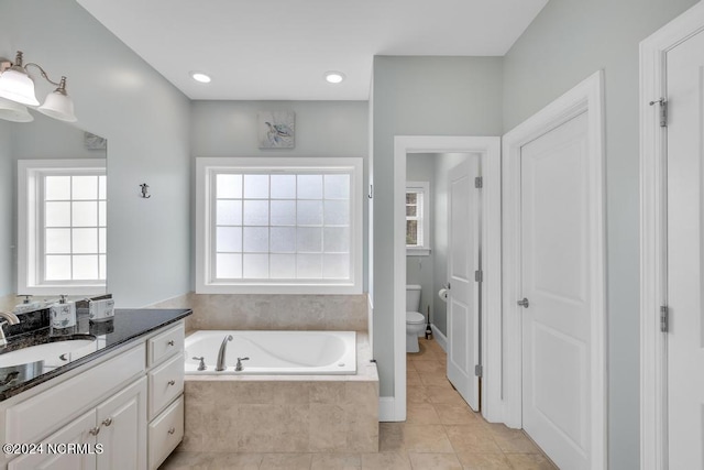 bathroom with tile patterned floors, a relaxing tiled tub, vanity, and a wealth of natural light