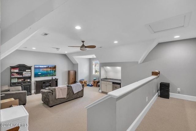 living room with ceiling fan, light colored carpet, and vaulted ceiling