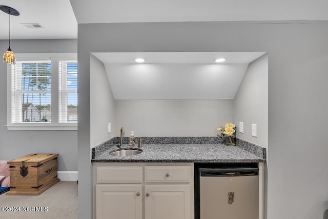 kitchen featuring white cabinetry, sink, stainless steel dishwasher, pendant lighting, and vaulted ceiling