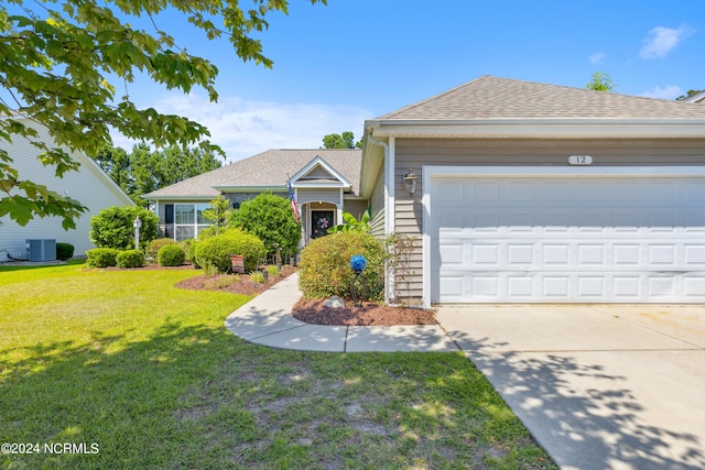 view of front of house with a front lawn, central AC unit, and a garage