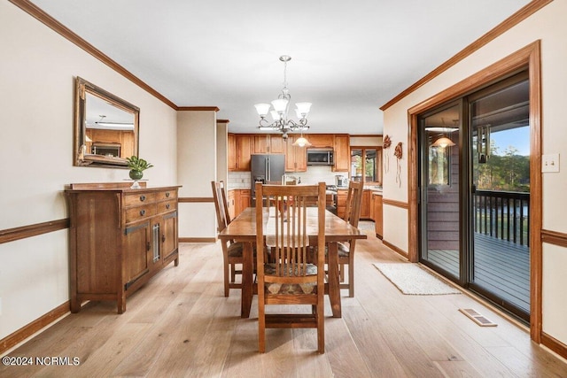 dining room featuring ornamental molding, a chandelier, and light wood-type flooring