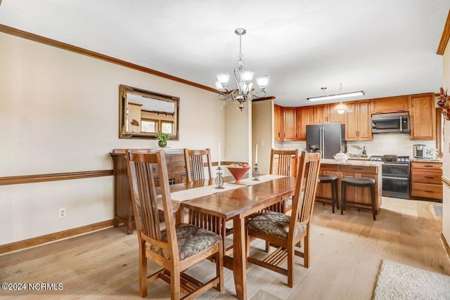 dining area with ornamental molding, a notable chandelier, and light wood-type flooring