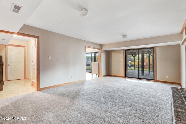 spare room featuring light colored carpet and plenty of natural light