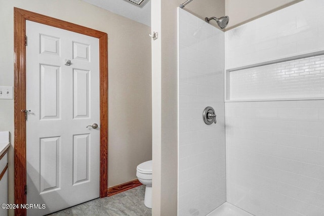 bathroom with vanity, a tile shower, hardwood / wood-style floors, and toilet