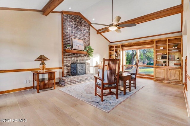 living room featuring ceiling fan, brick wall, light hardwood / wood-style floors, a brick fireplace, and lofted ceiling with beams