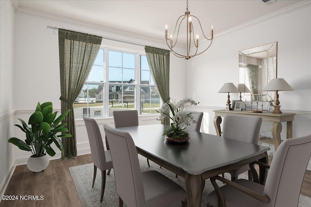 dining room with crown molding, hardwood / wood-style floors, and an inviting chandelier