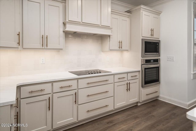 kitchen with light stone counters, stainless steel appliances, custom range hood, dark wood-type flooring, and backsplash