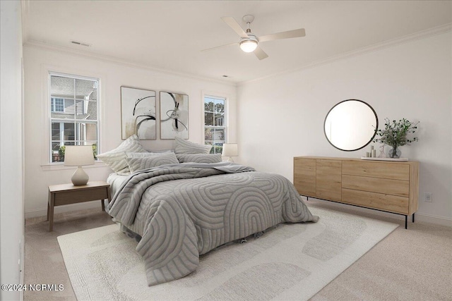 bedroom with ornamental molding, light carpet, multiple windows, and ceiling fan