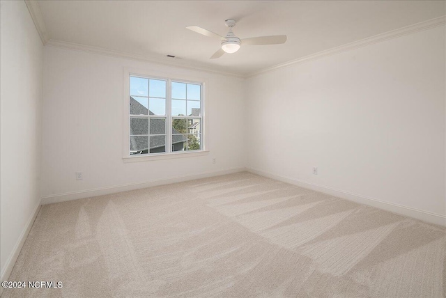 spare room with ceiling fan, ornamental molding, and light carpet