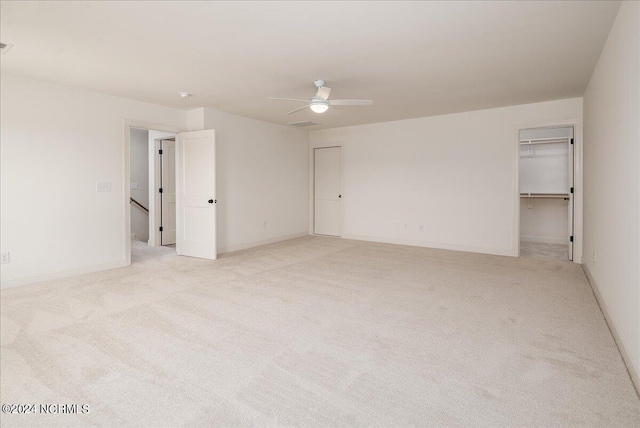 empty room featuring ceiling fan and light carpet