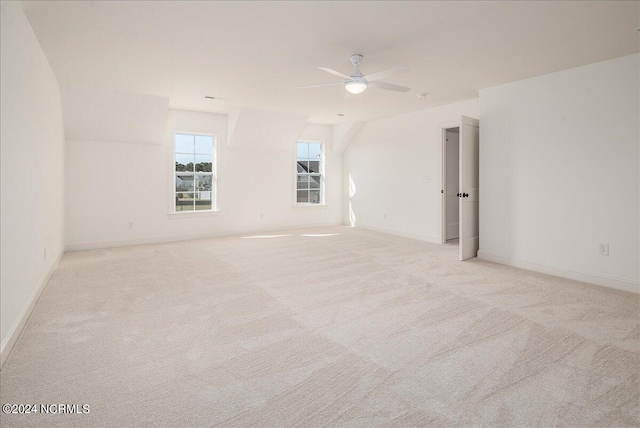 spare room with ceiling fan and light colored carpet