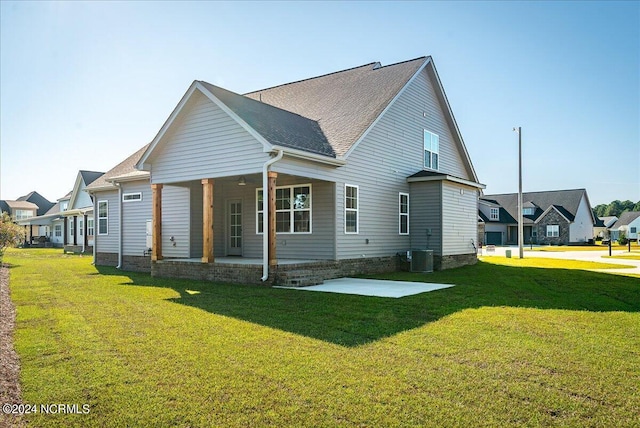 back of house featuring cooling unit and a lawn