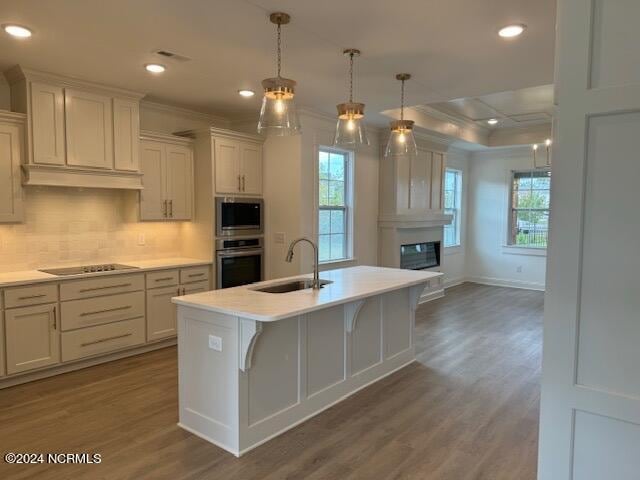 kitchen with crown molding, sink, black electric stovetop, and white cabinets