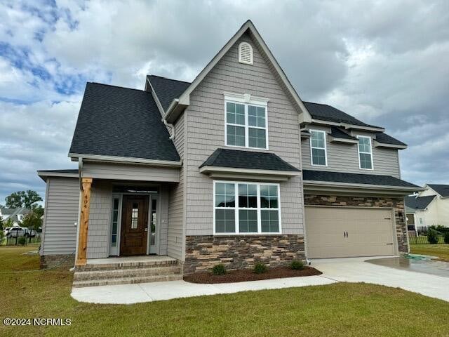 craftsman inspired home with a garage and a front lawn