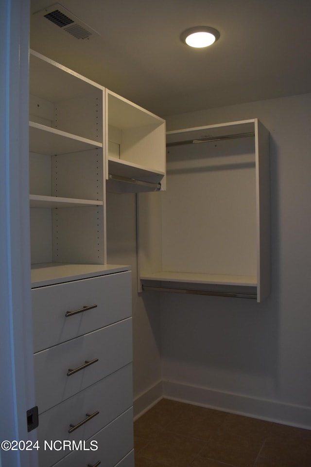 spacious closet featuring dark tile patterned floors