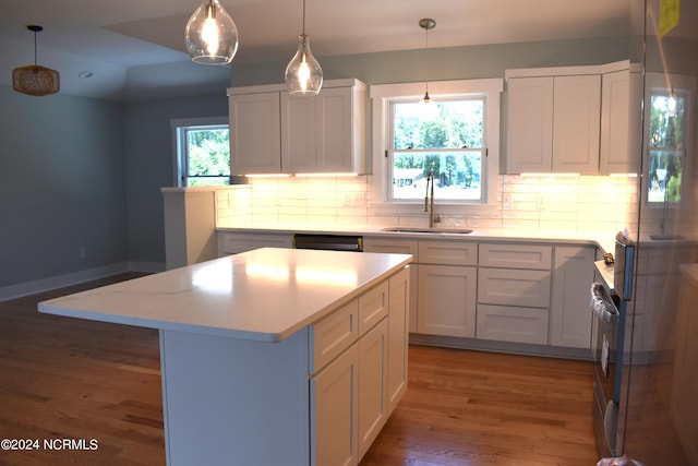 kitchen with sink, wood-type flooring, decorative backsplash, and plenty of natural light